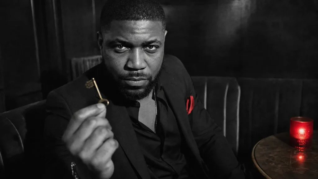 A man in a velvet booth holds out a brass key toward the camera. (AI-generated image) A man in a velvet booth holds out a brass key toward the camera. (AI-generated image)